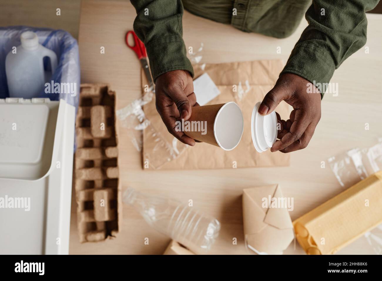 Vue de dessus gros plan de l'homme afro-américain préparant les déchets ménagers pour le recyclage, l'espace de copie Banque D'Images