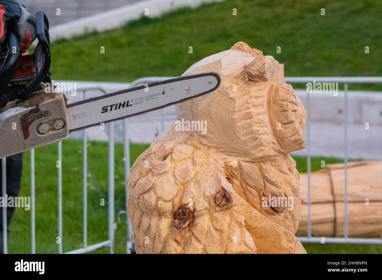 Gros plan : menuisier utilisant une tronçonneuse pour sculpter des sculptures en bois Banque D'Images