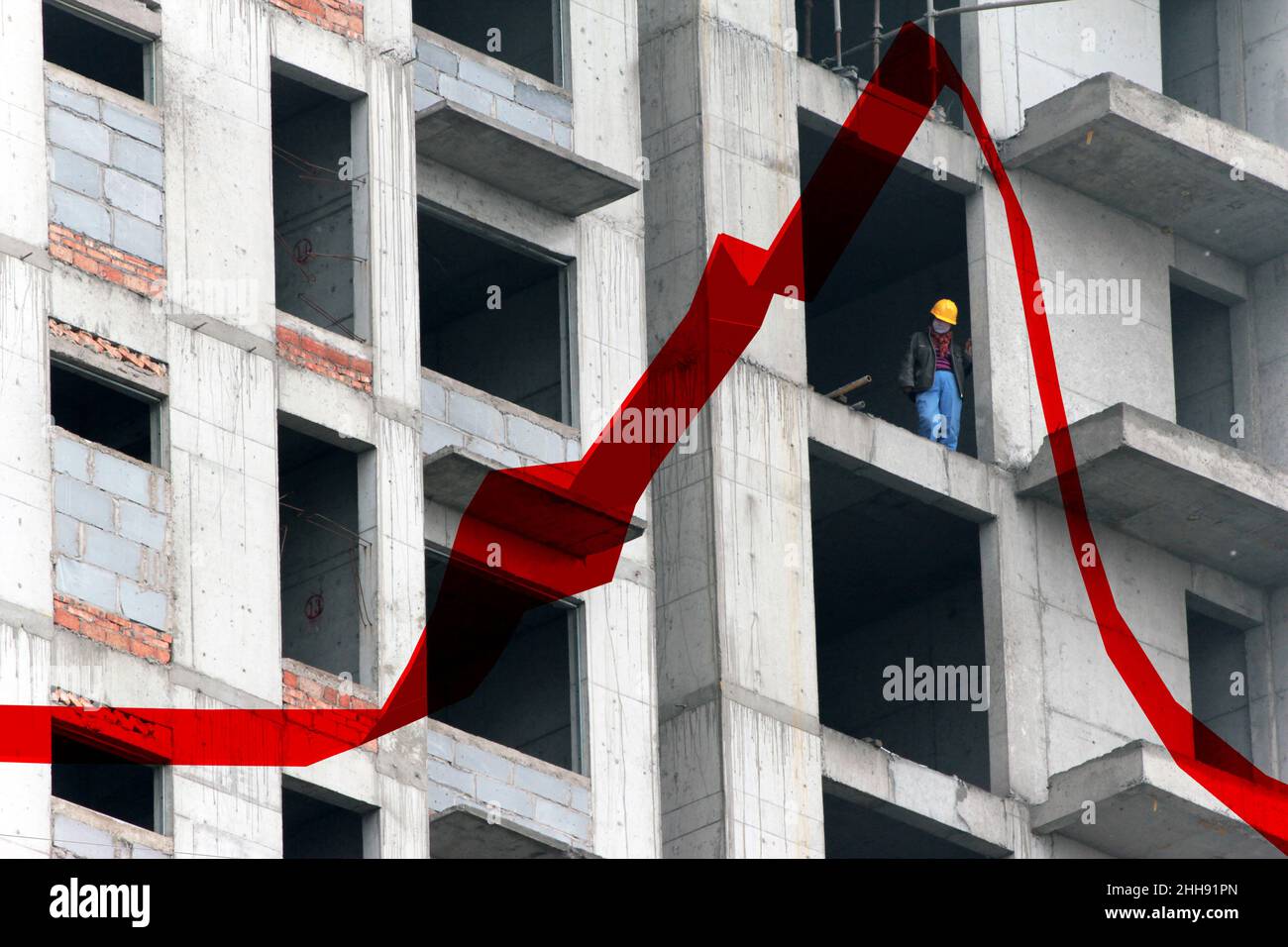 Un ouvrier de la construction dans un immeuble d'appartements, Chine.La tendance rouge reflète l'augmentation des prix de l'immobilier. Banque D'Images