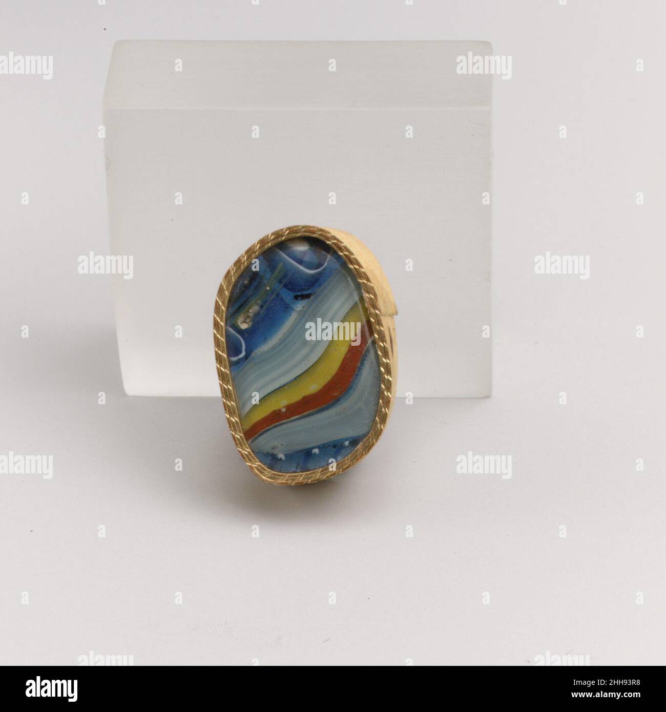 Fragment de mosaïque à rayures de verre fin du 1st siècle C.-B.–début du 1st siècle A.D. Roman bleu cobalt translucide, blanc opaque, jaune et rouge brique.Côté incurvé convexe.bobine en bleu avec fil hélicoïdal simple en blanc; motif rayé formé de longueurs de différentes cannes: Une en bleu avec une couche blanche; une autre en bandes de rouge et jaune;Une canne polygonale au sol bleu avec un cercle blanc et une tige centrale blanche, alternant avec une canne carrée en bleu avec une couche blanche.extérieur poli et bord; piqûres de bulles de surface à l'extérieur; altération bleutée et légère irisée à l'intérieur.Probabl Banque D'Images