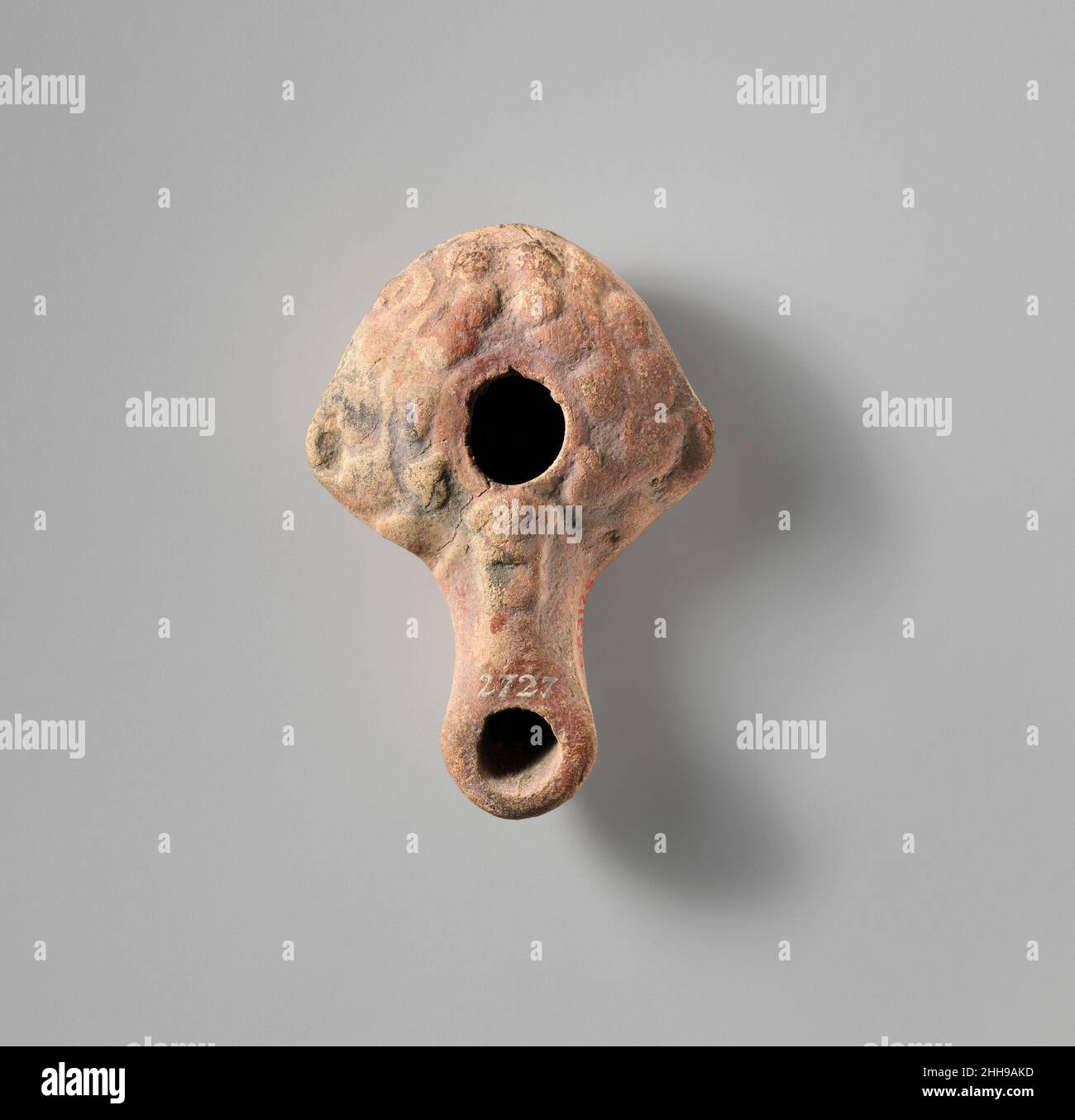 Lampe à huile en terre cuite grecque moulée.Corps presque triangulaire.Grand orifice de remplissage central, légèrement irrégulier entouré d'un bord étroit.Épaule convexe courbeuse, décorée en relief avec des tendrils à feuilles de lierre assortis de chaque côté et de petits boutons tournés sur les côtés.Large, long bec, orné d'un masque Silenus à l'arrière et d'un grand trou de mèche rond.Non défini, base plate.intacte...Lampe à l'huile en terre cuite.Grec.Terre cuite.Hellénistique.Terracottas Banque D'Images