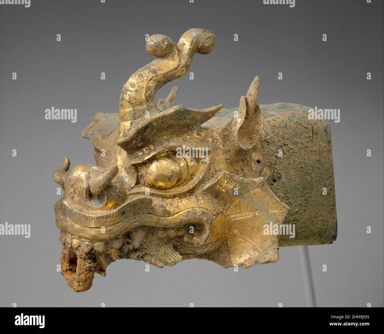 Finale de rafter en forme de tête d'un dragon et carillon de vent Corée du 10th siècle ce dernier en forme de tête d'un dragon aurait été initialement attaché à un rafter d'angle d'une salle royale ou d'un bâtiment de temple bouddhiste (voir, par exemple,La photographie à droite d’une pagode en modèle de bois de la dynastie Goryeo). Les yeux renflés, les narines torrencieuses et les écailles élaborées de la bête témoignent de la force et de l’invincibilité de cette créature prometteuse.La cloche, qui fonctionnait comme un carillon de vent, avait une plaque de métal clapper à l'intérieur et aurait été suspendue par un crochet de la boucle au pe Banque D'Images