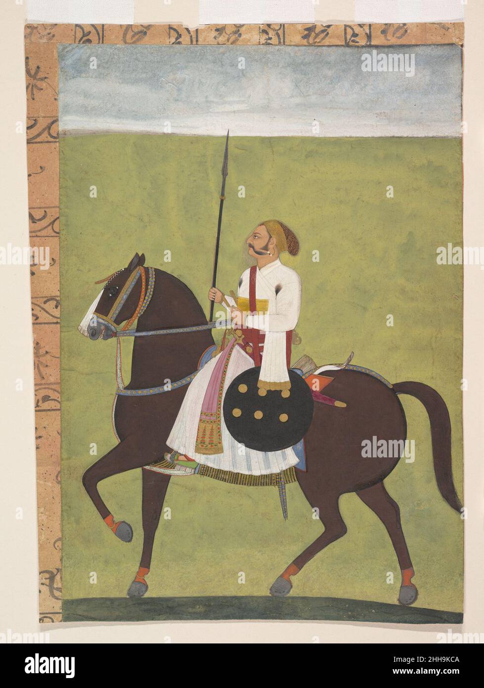 Portrait équestre d'un noble ca.1710–20 Inde (Rajasthan, Jodhpur) en utilisant des champs de couleur audacieux, cet artiste Marwari se concentre sur la figure primaire, lui donnant une grande présence.Le bouclier et la lance soulignent le statut du noble sur le champ de bataille et, par conséquent, au tribunal.La représentation accomplie du visage du cavalier en profil et son costume subtilement rendu confirment les liens avec la tradition de peinture de Mughal dans la cour de Jodhpur pendant cette période sous l'artiste Dalchand.Portrait équestre d'un noble 65003 Banque D'Images