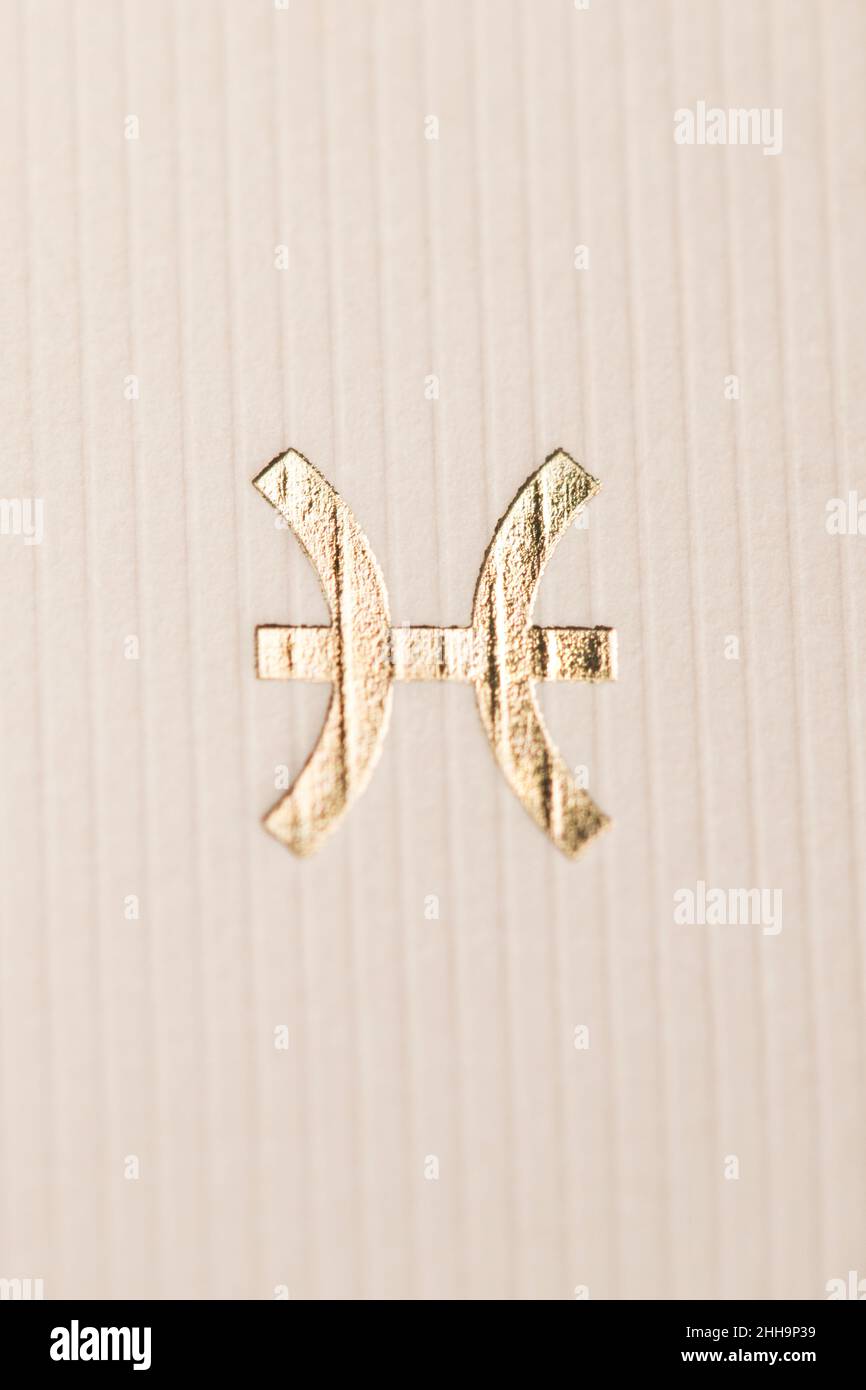 Gros plan horoscope signe du symbole du zodiaque en feuille d'or représentant la constellation des poissons Banque D'Images