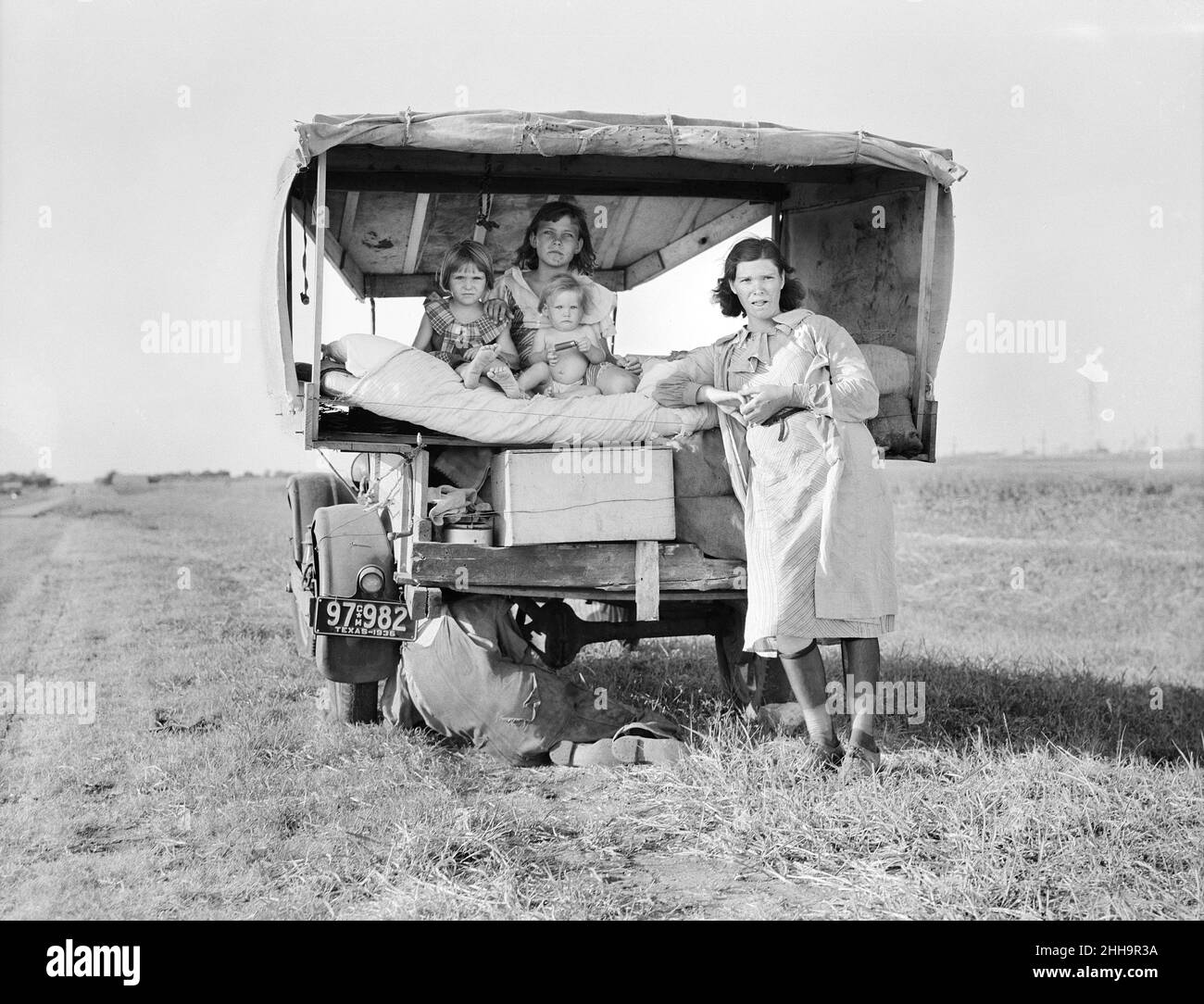 Portrait de la famille migrant alors que le père est en train de réparer le pneu de voiture, Texas, USA, Dorothea Lange, U.S. Office of War information/U.S.Administration de la sécurité agricole, août 1936 Banque D'Images