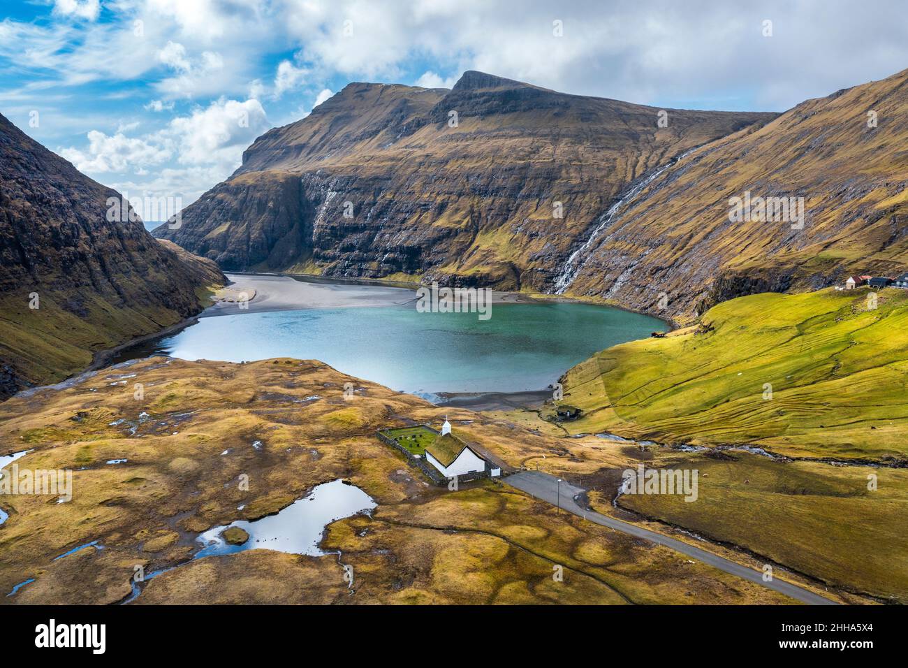 Photo aérienne d'une église pittoresque en face d'un petit lac, à Saksun, îles Féroé. Banque D'Images