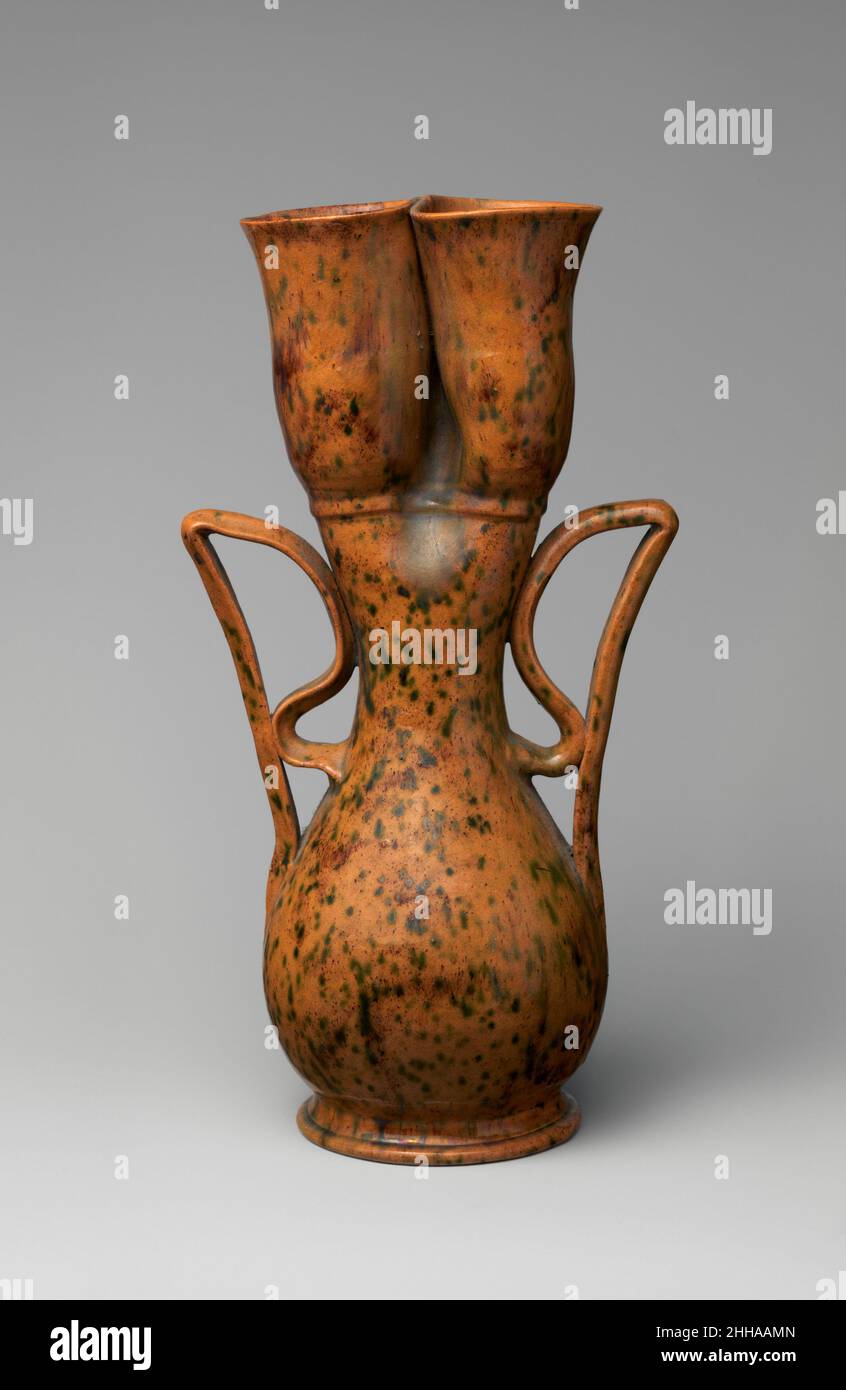 Vase ca.1897–1900 George E. OHR George OHR de Biloxi, Mississippi, était sans doute le potier artistique américain par excellence : il construisit son propre four, creusa de l'argile, jeta ses vaisseaux avec une extrême compétence sur la roue du potier pour galer la finesse, altéra ces formes, puis les couvra avec ses propres glaçures originales.Dans la forme et la décoration, ce sont essentiellement des objets expressionnistes abstraits, presque 50 ans avant la création de ce mouvement.Ces deux vases illustrent particulièrement bien la façon dont les poignées en ruban de la manne, flamboyante, de l’OHR transforment une forme traditionnelle de navire.Sur l'un, l'ajout de la serpentine Banque D'Images