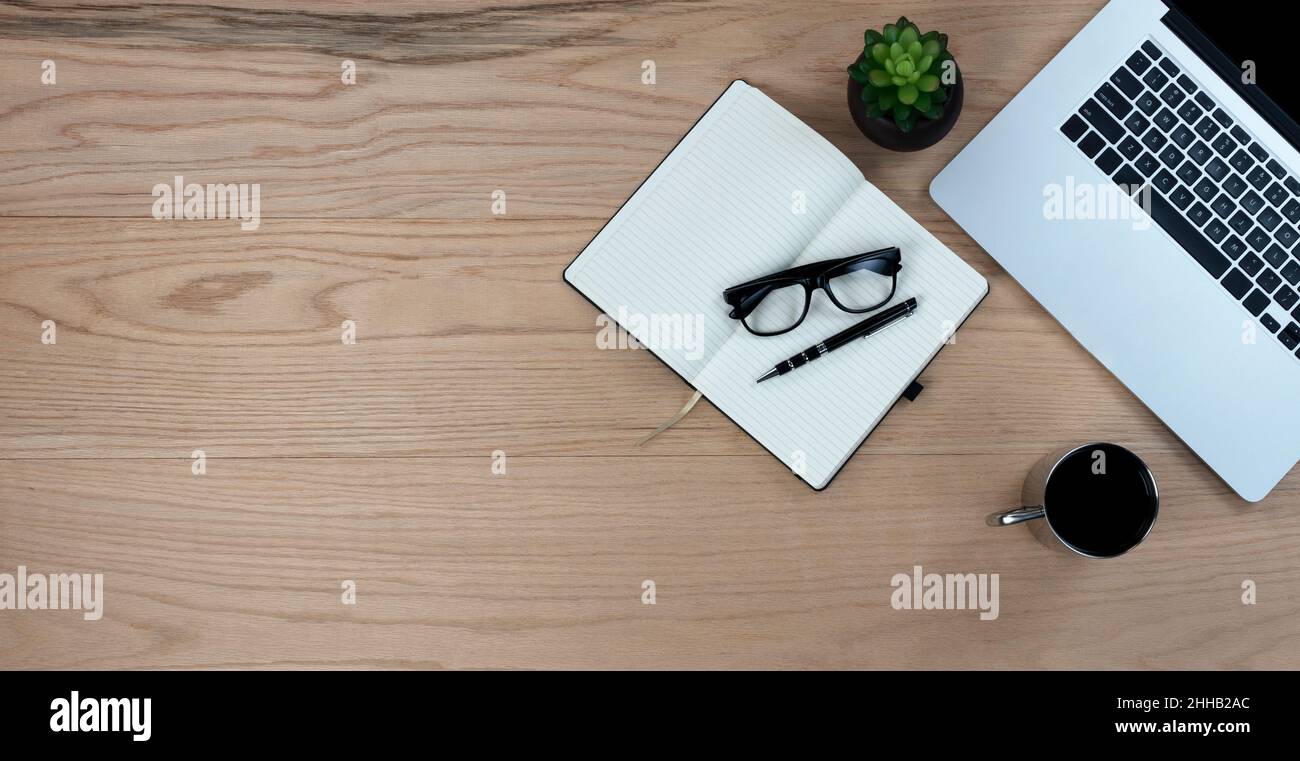Bureau en chêne bureau table avec ordinateur portable, matériel d'écriture et café pour le travail ou l'école.Vue de dessus avec espace de copie au format de mise à plat. Banque D'Images
