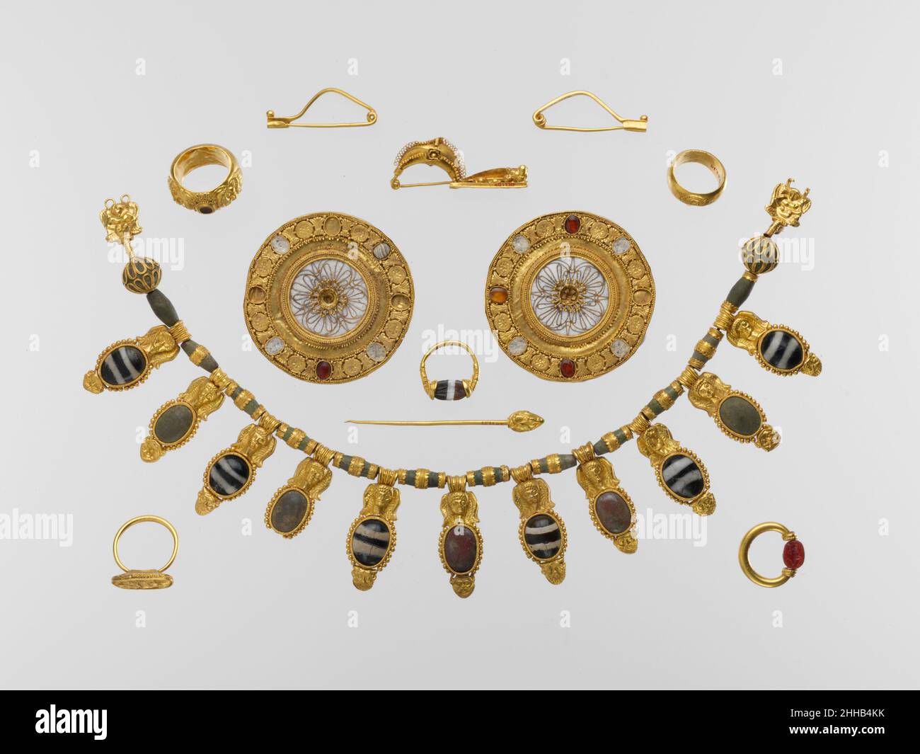 Ensemble de bijoux début de 5th siècle avant J.-C. étrusque le groupe de tombeau représente l'un des ensembles les plus riches et les plus impressionnants de bijoux étrusque jamais trouvé.Il comprend un magnifique collier en or et verre, une paire de boucles d'oreilles disques en or et cristal de roche, une attache de robe dorée (péroné) décorée d'un sphinx, une paire de péronés dorés, une épinglette en or et cinq anneaux de doigt.Deux des anneaux ont des scarabs gravés qui tournent sur un cadre pivotant; l'un est décoré avec des têtes satyr en relief, et les deux autres ont des encadrements dorés décorés.Écoutez des experts illuminer l'histoire de cette œuvre Écoutez PL Banque D'Images