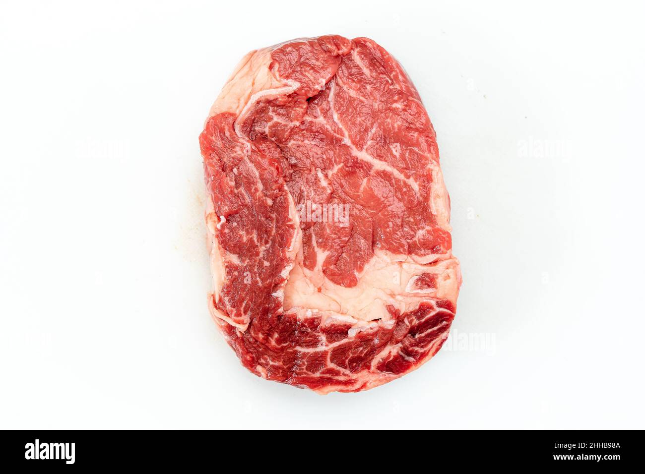 Steak de bœuf cru sur fond blanc. Vue sur le dessus Banque D'Images