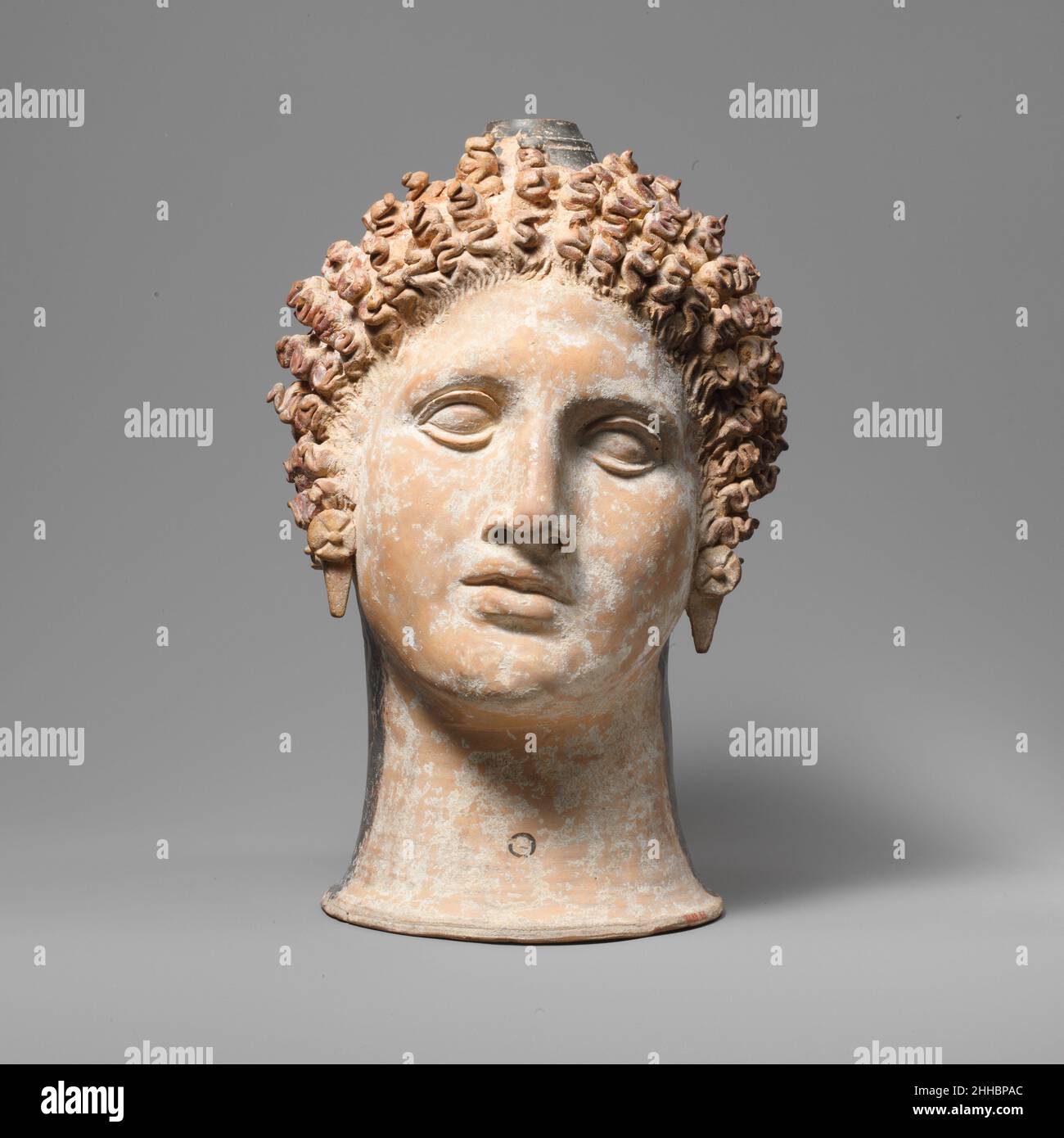 Terre cuite lekythos (ballon à huile) ca.400–375 C.-B. grec, sud-italien, Apulian tête d'une femmesEn l'absence de pierre de qualité sculpturale abondante, les artistes du sud de l'Italie ont utilisé l'argile pour un grand effet artistique.La tête est impressionnante pour sa taille, le rendu sensible du visage, la texture des cheveux, et l'articulation soigneuse des boucles d'oreilles.Lekythos en terre cuite (fiole à huile) 251089 grec, italien du Sud, apulien, lekythos en terre cuite (fiole à huile), env.400?375 C.-B., terre cuite, H. 14 7/16 po.(36,7 cm).Metropolitan Museum of Art, New York.Fonds Rogers, 1921 (21.88.65) Banque D'Images