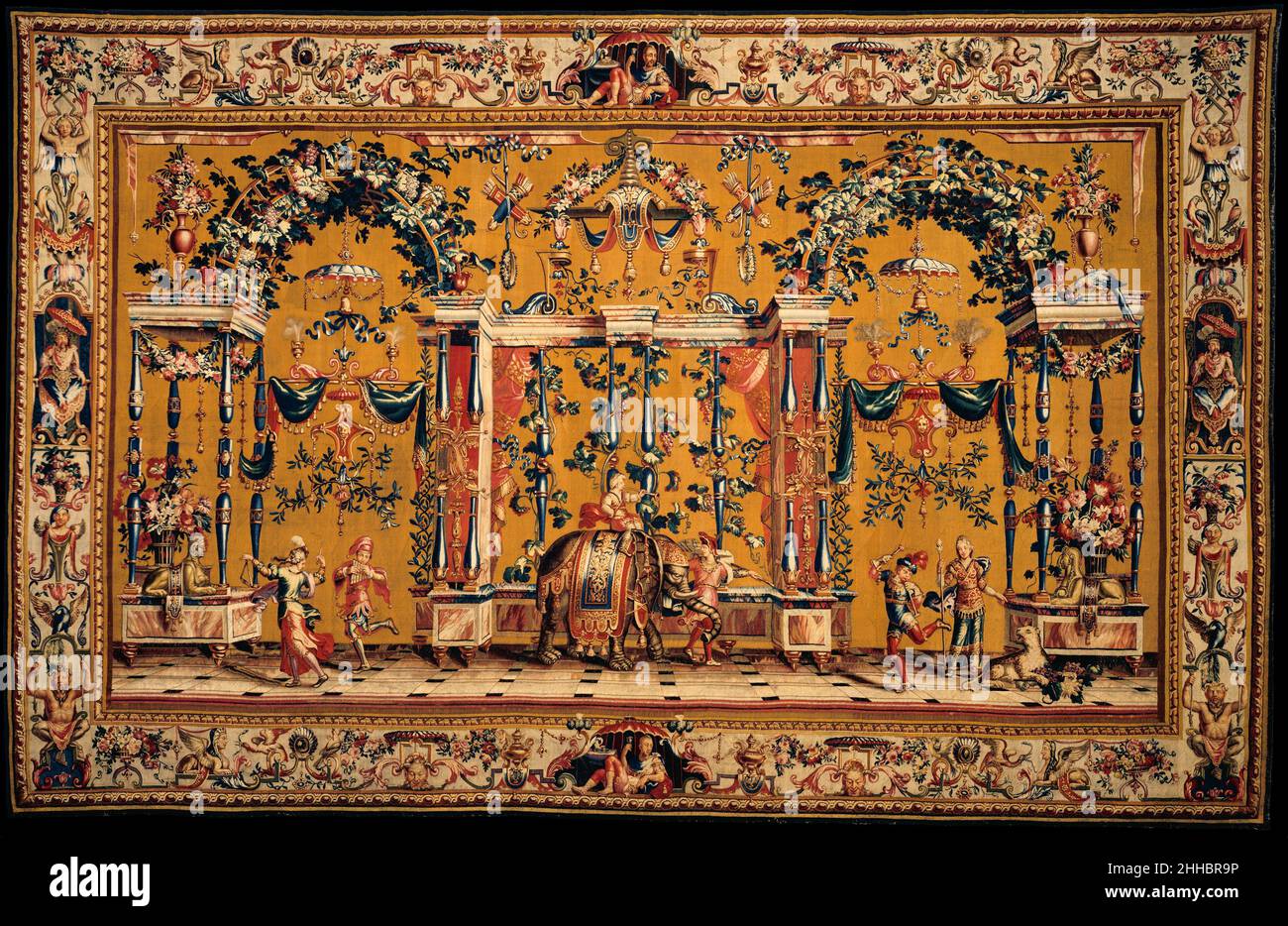 L'éléphant d'un ensemble de cinq Grotesques conçu ca.1688, env.1690–1711 conçue par Jean-Baptiste Monnoyer Français présentant des musiciens, des acrobates et des animaux exotiques dans un cadre architectural fantaisiste, cette tapisserie est issue d'un ensemble connu sous le nom de grottes de Berain, en référence à l'influence stylistique omniprésente de Jean Berain (1640–1711), qui peut même avoir fourni des croquis préliminaires.L'architecture classique, la flore, la faune et les figures contre le sol blanc étaient en émulation des peintures murales romaines excavées dans les chambres souterraines du palais de Néron à Rome (erreur Banque D'Images