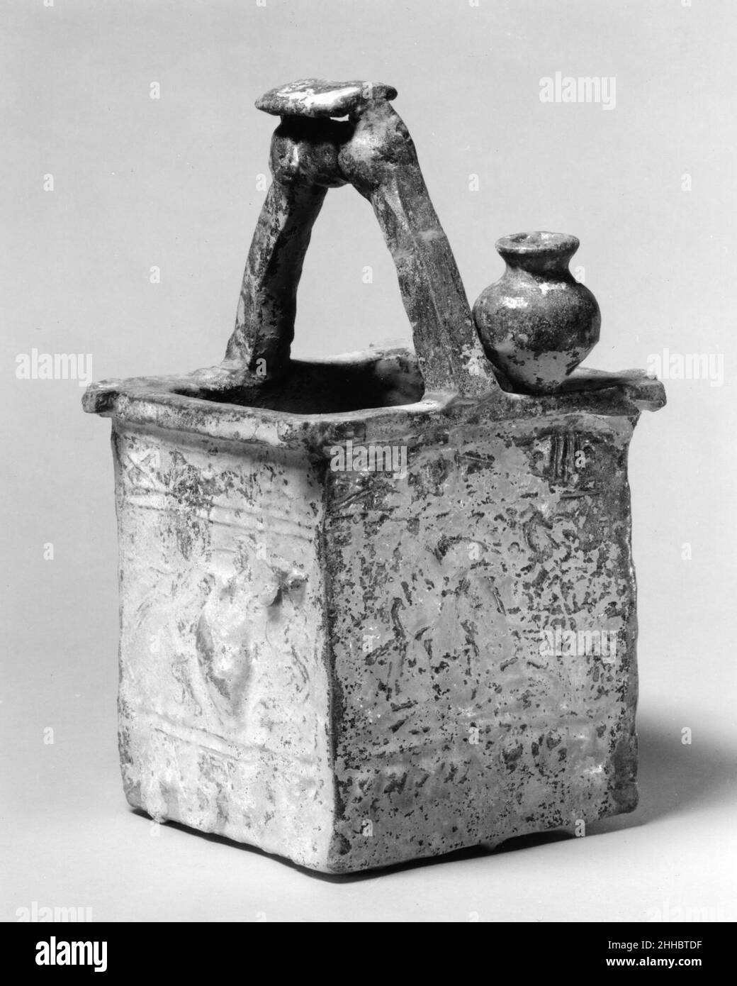 Tête de puits avec la Chine de seau la plus ancienne dynastie Han poterie se compose de meubles de tombeau tels que ce modèle d'une tête de puits.Souvent, ces marchandises à feu bas ont été embellies d'un vernis de plomb avec du cuivre ajouté pour produire une couleur verte.L'iridescence argentée à la surface de cette pièce est le résultat de la dégradation de la glaçure après des siècles d'inhumation dans un environnement humide.Tête de puits avec godet 44321 Banque D'Images