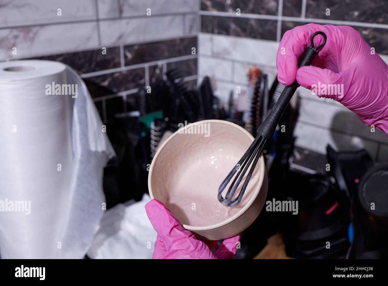 fille en caoutchouc blanc gants de protection tenant une brosse dans ses mains et en remuant colorant capillaire coloriste gros plan soins des cheveux à la maison masque de cheveux Banque D'Images