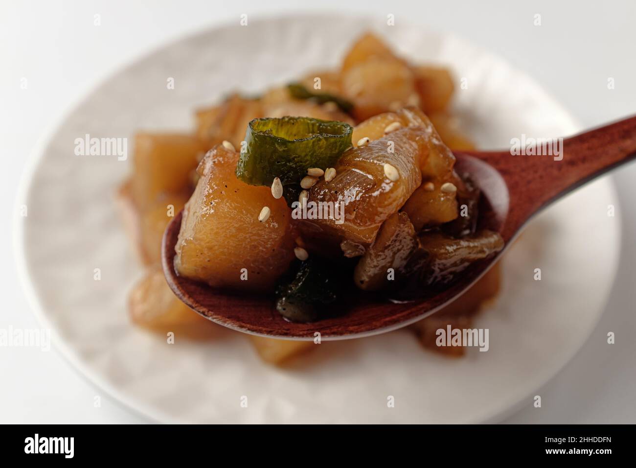 Pommes de terre mijotées dans de la sauce soja sur fond blanc Banque D'Images