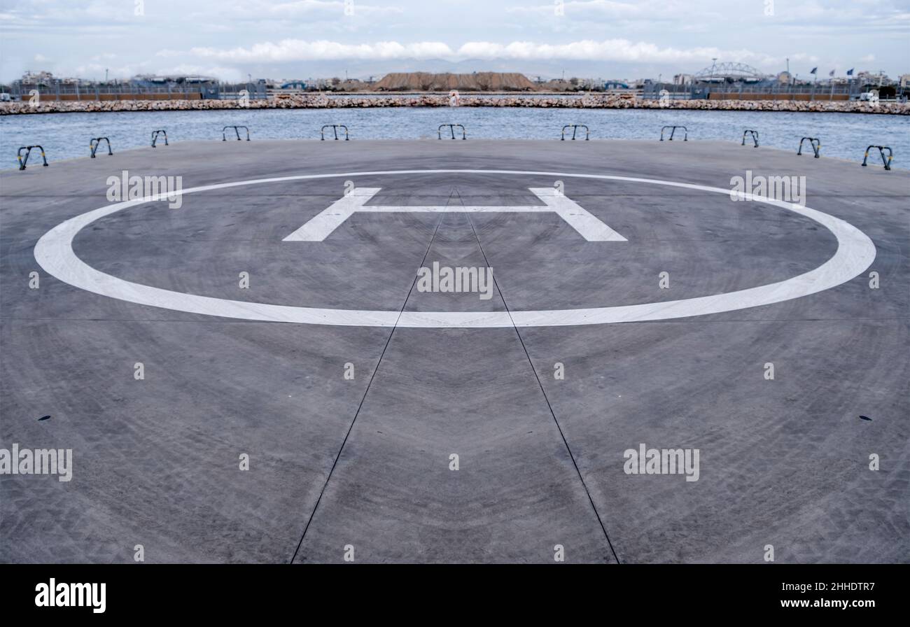 Signe héliport, lettre jaune H au sol.Zone d'atterrissage par hélicoptère au bord de la mer, Athènes Grèce. Banque D'Images