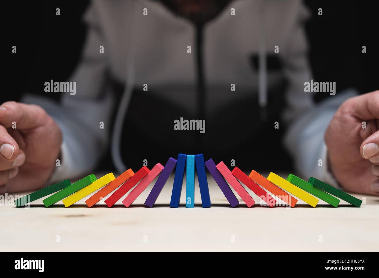 Dominos de couleur qui sont tombés des deux côtés et le milieu est encore debout et porte toute la pression. Banque D'Images