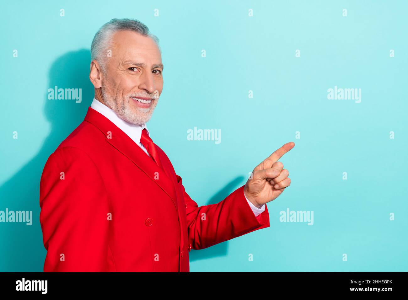 Photo de charismatique retraité homme porter rouge trois pièces costume pointant espace vide isolé turquoise couleur fond Banque D'Images