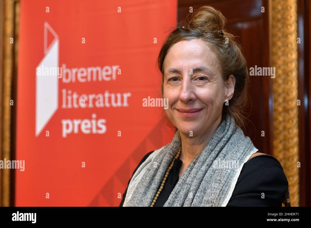 24 janvier 2022, Brême: La lauréate, l'écrivain Judith Hermann, se dresse devant l'affiche du prix de littérature de Brême.Selon le Sénat de Brême, l'auteur, né à Berlin en 1979, reçoit le prix de 25 000 euros pour son roman « Daheim » (S.Fischer Verlag).Le prix est décerné par la Fondation Rudolf Alexander Schröder depuis 1953.Photo: Michael Bahlo/dpa Banque D'Images