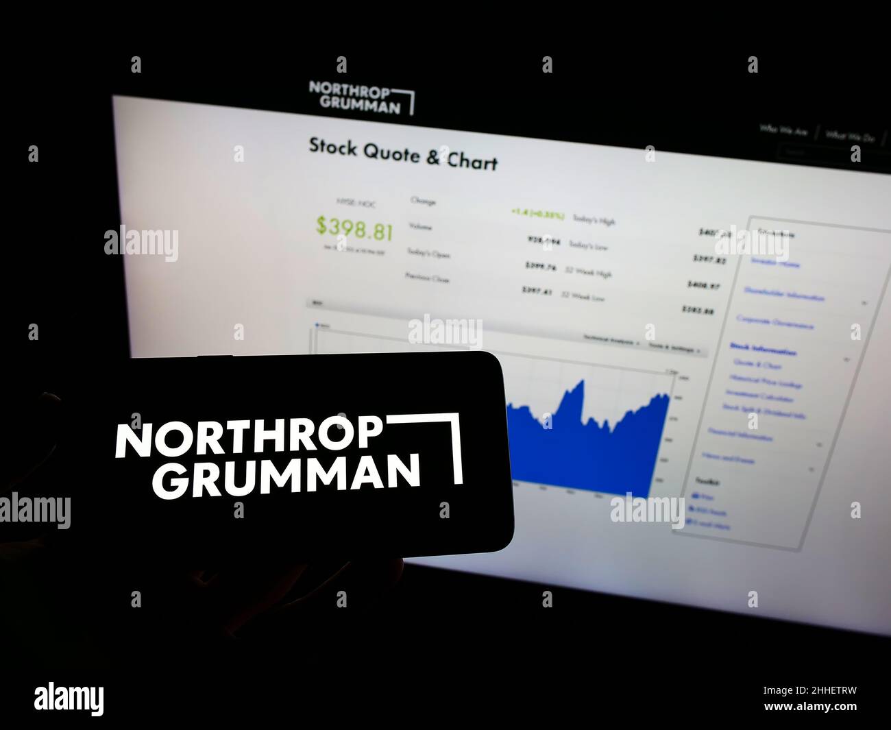 Personne tenant un téléphone portable avec le logo de la compagnie de défense américaine Northrop Grumman Corporation à l'écran devant la page Web.Mise au point sur l'affichage du téléphone. Banque D'Images