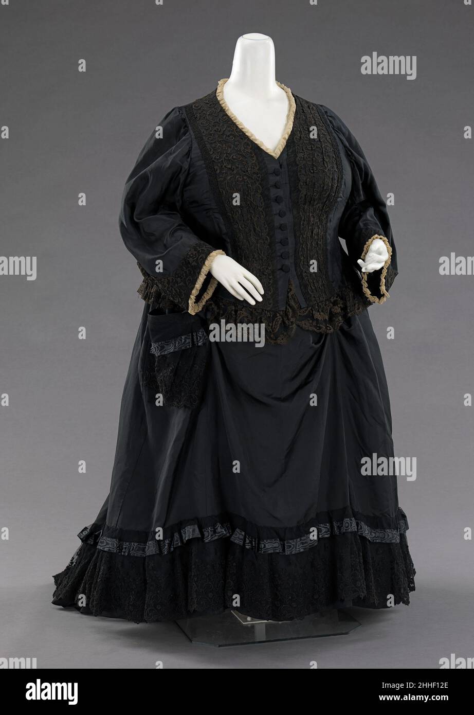 Robe de deuil 1894 britannique cette robe a été portée par la reine Victoria (1819-1901) du Royaume-Uni, comme le documente une photographie de 1894 de la reine tenant son arrière-petit-fils, Edward VIII (1894-1972).Achetée à la vente annuelle des vêtements de la Reine, elle montre les touches traditionnelles de la tenue de deuil, qu'elle a portée de la mort de son mari, le Prince Albert (1819-1861), jusqu'à sa propre mort.La bordure blanche simple et l'utilisation minimale de crêpe froissée sur la robe indiquent un état de demi-deuil, bien qu'il soit 33 ans après la mort de son mari.Le corsage est d'un matériau plus léger Banque D'Images