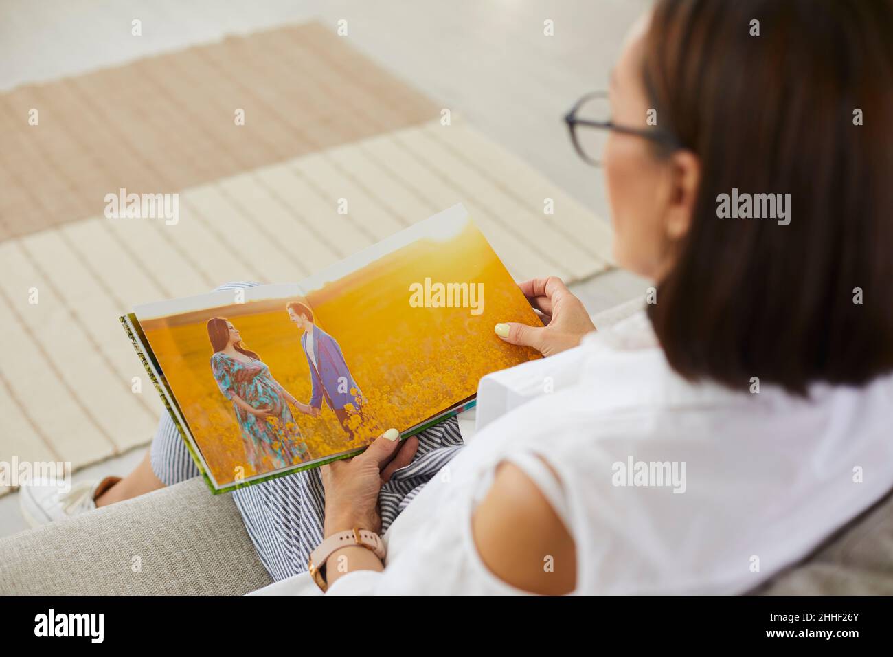 Femme regardant à travers des photos de maternité photoshoot dans un album de famille ou un photolivre Banque D'Images
