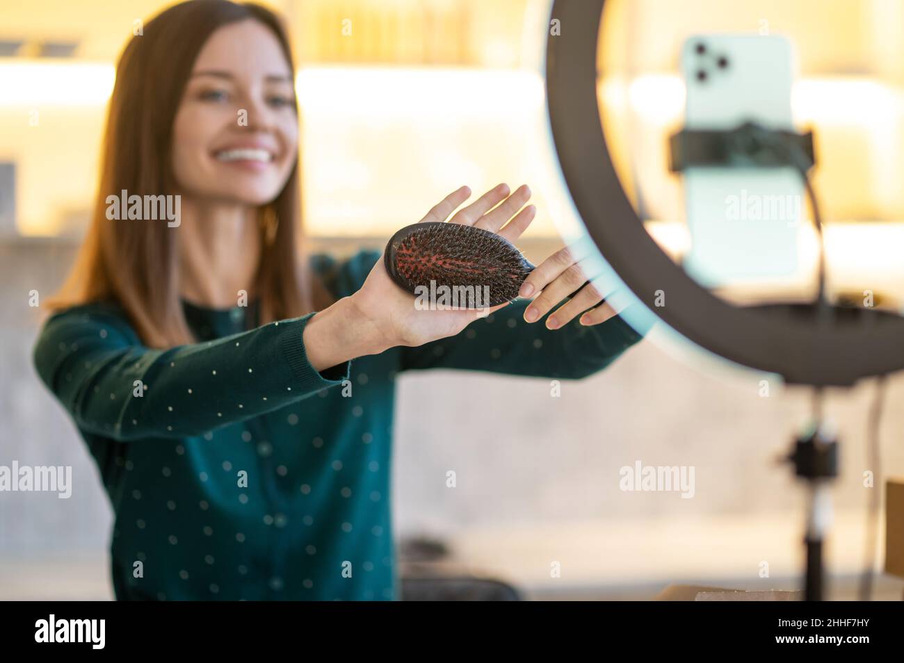 Jeune femme souriante montrant des conseils sur le soin des cheveux Banque D'Images