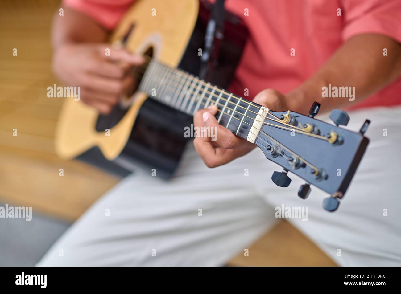 Mains d'un homme à la peau sombre jouant de la guitare Banque D'Images
