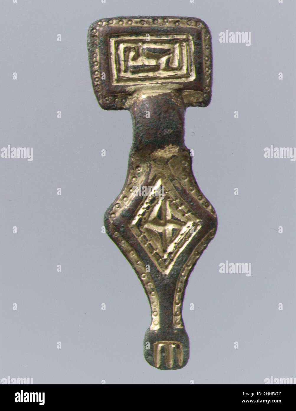 Broche miniature à tête carrée 500–550 anglo-saxonne l'affinité de ces broches, que l'on trouve en France, avec des objets du Kent est la preuve de la propagation des traditions artistiques par l'exportation ou la copie.Broche miniature à tête carrée 465093 broche anglo-saxonne miniature à tête carrée, 500?550, dorée en argent ; broche en fer,Total : 1 3/4 x 5/8 x 3/8 pouces(4,5 x 1,6 x 0,9 cm).Metropolitan Museum of Art, New York.Don de J. Pierpont Morgan, 1917 (17.191.46) Banque D'Images