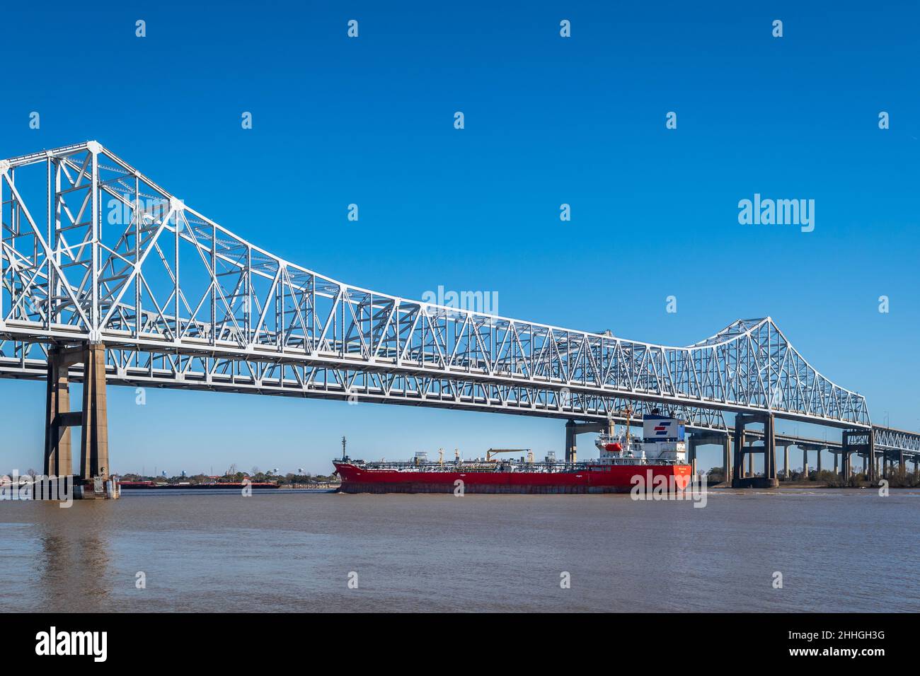 Port de la Nouvelle-Orléans sur le fleuve Mississippi avec un bateau, un bateau, une barge, passant sous le pont du fleuve Mississippi, Louisiane, Etats-Unis. Banque D'Images