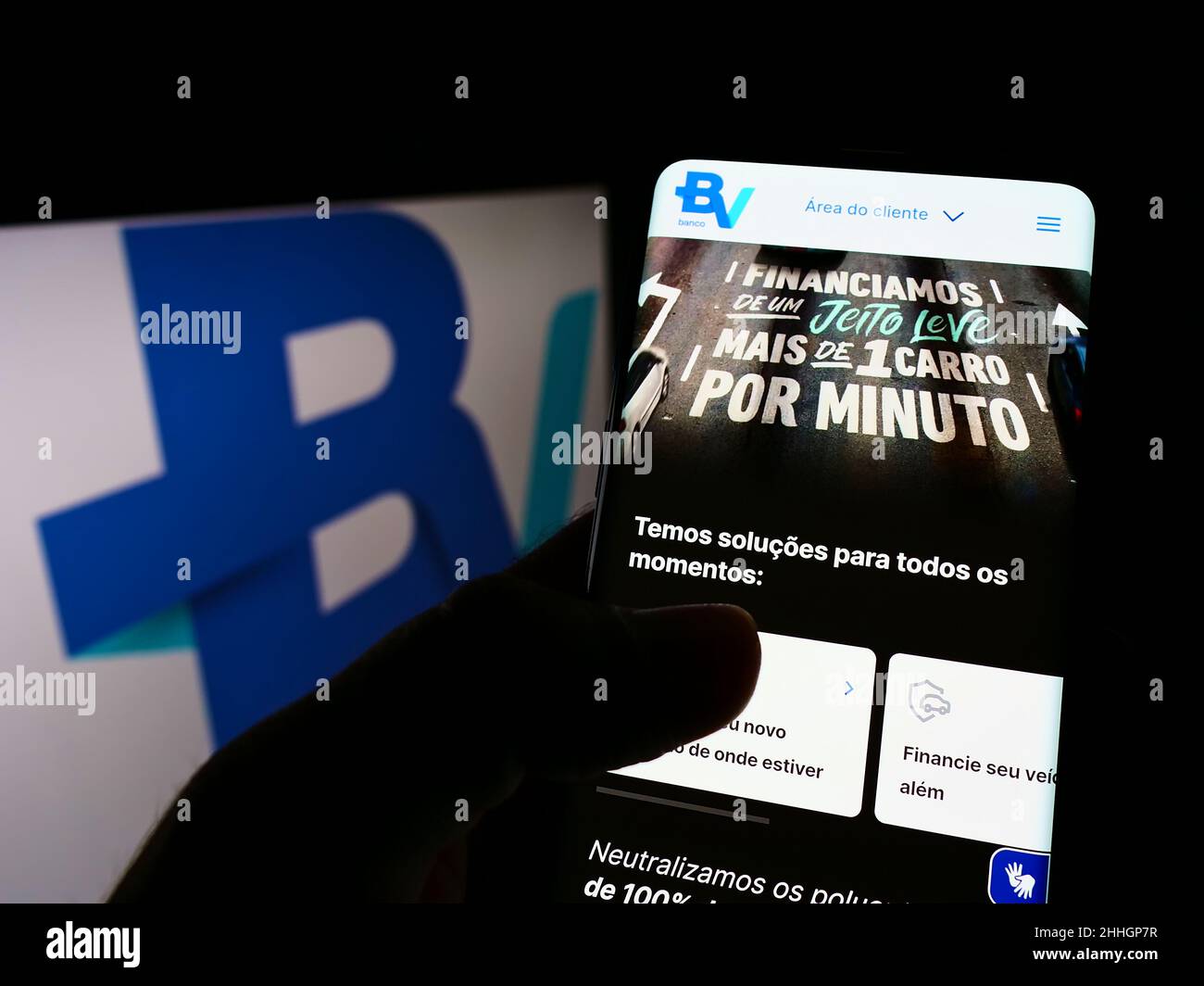 Personne tenant le téléphone portable avec le site de la société brésilienne Banco Votorantim S.A. sur l'écran devant le logo.Concentrez-vous sur le centre de l'écran du téléphone. Banque D'Images