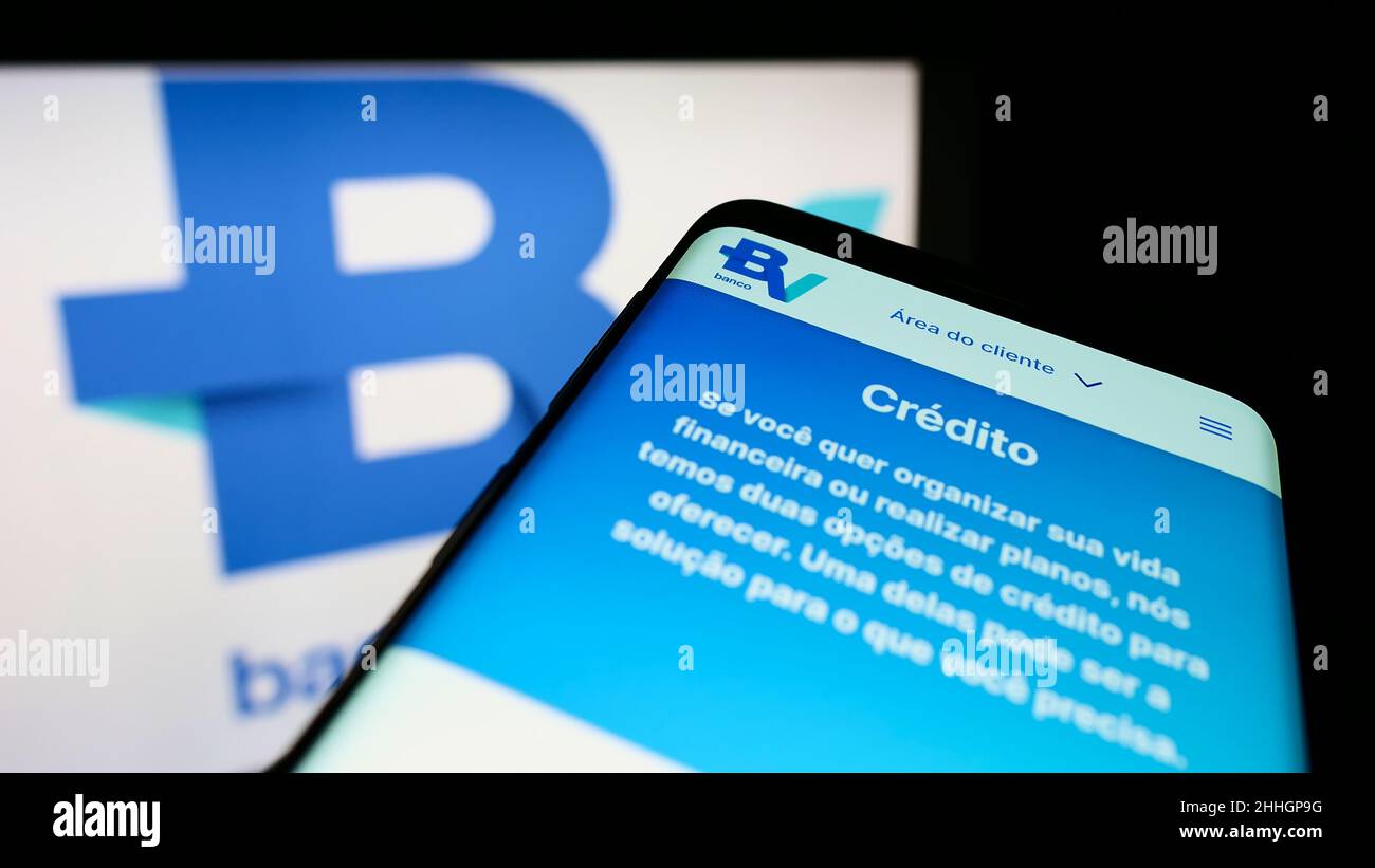 Smartphone avec la page web de la société brésilienne Banco Votorantim S.A. à l'écran devant le logo de l'entreprise.Faites la mise au point dans le coin supérieur gauche de l'écran du téléphone. Banque D'Images