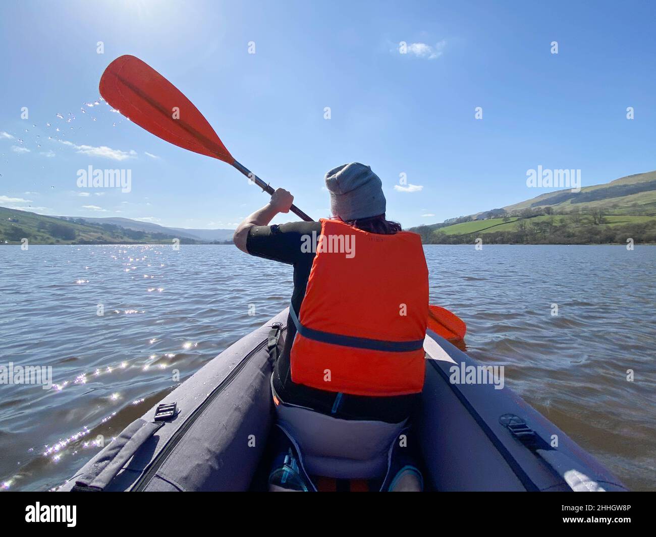 Vue arrière d'une femme en kayak sur le lac par beau temps Banque D'Images Vue arrière d'une femme en kayak sur le lac par beau temps Banque D'Images