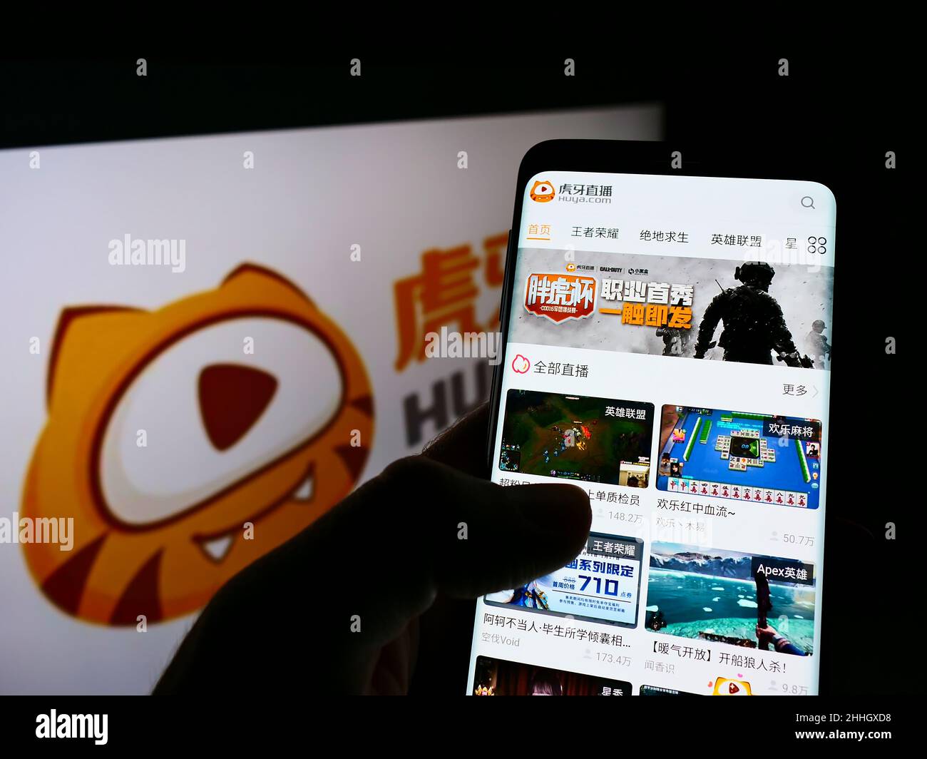 Personne tenant un téléphone portable avec le site Web de la société chinoise de streaming HUYA Inc. À l'écran devant le logo.Concentrez-vous sur le centre de l'écran du téléphone. Banque D'Images