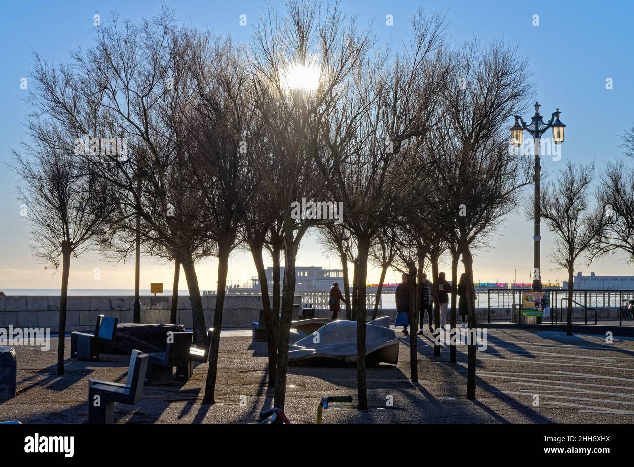 La promenade sur le front de mer de Worthing pendant une journée d'hiver ensoleillée avec un soleil bas débordant d'arbres créant de fortes ombres West Sussex Angleterre Royaume-Uni Banque D'Images