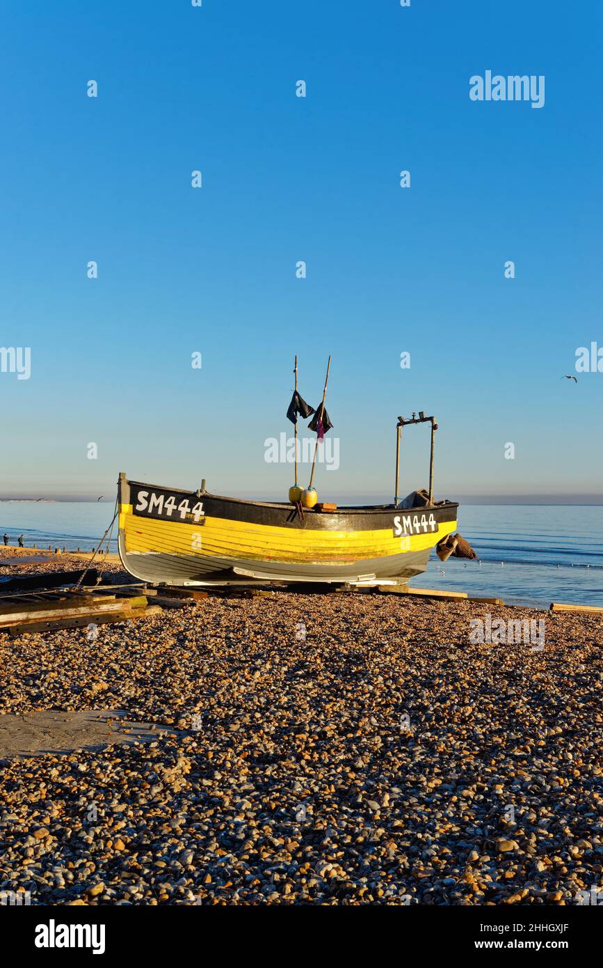 Un bateau de pêche traditionnel sur l'East Beach à Worthing lors d'une journée hivernale ensoleillée avec une mer calme en arrière-plan à l'ouest du Sussex Angleterre Royaume-Uni Banque D'Images