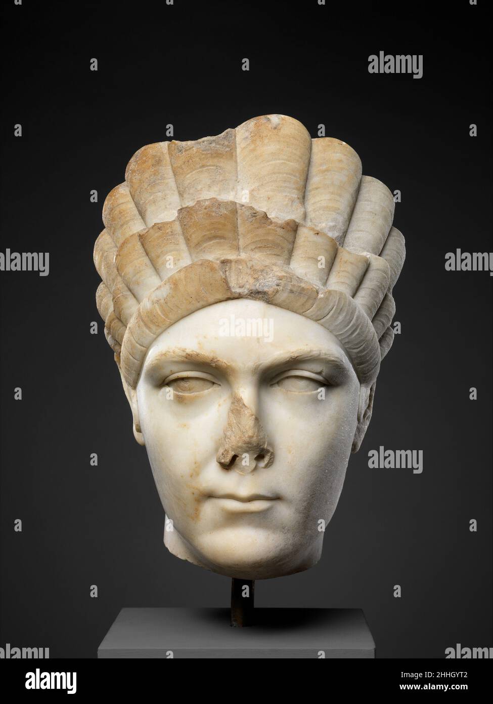 Portrait en marbre de Marciana, sœur de l'empereur Trajan ca.A.D. 130–138 Roman pendant le dernier quart du premier siècle A.D. et les premières décennies du deuxième siècle A.D., des arrangements de cheveux toujours plus complexes ont été développés pour les dames de la cour impériale.Des coiffures avec des cheveux ajoutés et des cadres dissimulés ont formé de hautes structures ressemblant à un diadème entourant le visage.Une des constructions les plus élaborées figure sur les portraits officiels de Marciana, la sœur aînée de Trajan.Le haut vernis et les yeux gravés sur cette tête suggèrent qu'elle a été sculptée pendant la période hadrianique.Le Banque D'Images
