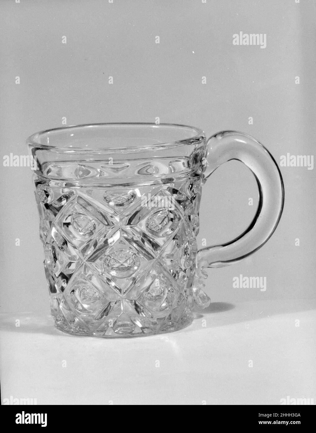 Whiskey Mug 1850–60 American avec le développement de nouvelles formules et techniques, la technologie de pressage du verre s'était nettement améliorée à la fin de 1840s.À ce moment-là, les tablewares pressés étaient produits dans de grands ensembles de correspondance et des formes innombrables.Au milieu de l'année 1850s, le verre incolore et les patrons géométriques simples dominaient.Répondant à la demande de produits de restauration à prix modéré, l'industrie du verre aux États-Unis s'est largement développée et de nombreuses usines ont fourni des verres pressés moins chers au marché en pleine croissance.À l’exposition de l’industrie de toutes les nations de Crysta à New York Banque D'Images