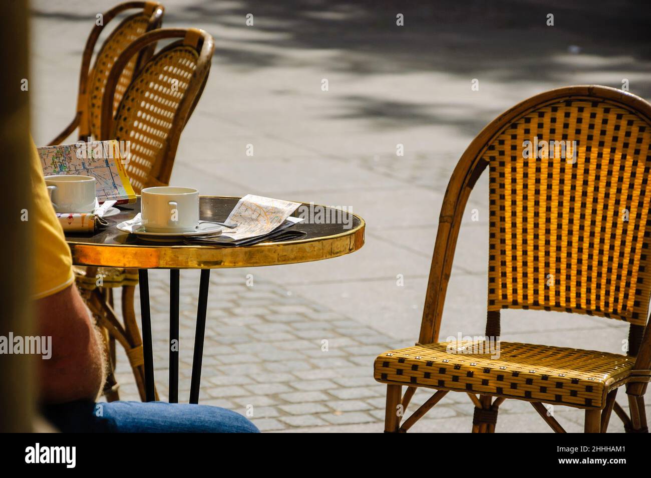 PARIS, FRANCE - 14 AOÛT 2014 : séance touristique sur la terrasse du café le Nemours avec une tasse de café, un guide de la ville (en allemand) et un plan.Ce café populaire je Banque D'Images