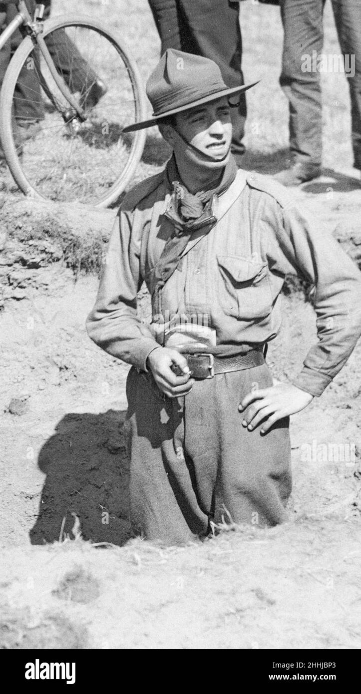 Un scout de garçon se tient dans l'un des cratères faits à la suite de l'une des trois raids aériens faits sur la ville par les navires allemands Zeppelin à la fin août 1914, comme les résidents regardent Banque D'Images