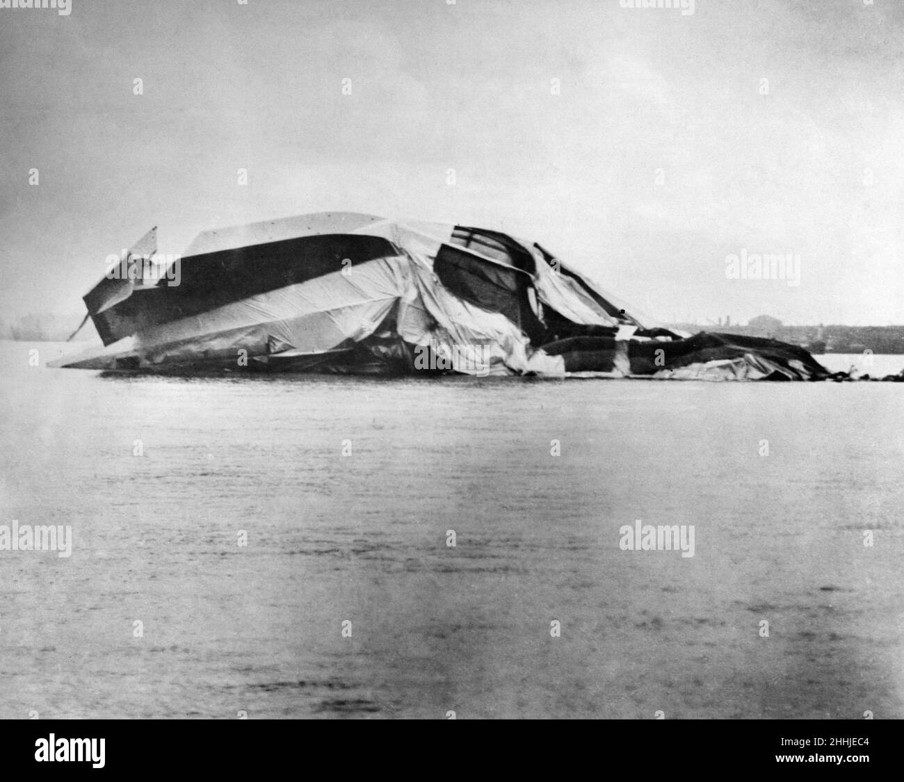 L'épave du navire de l'aviation de R38, après une rupture structurelle au cours de son quatrième vol d'essai avec la marine américaine au-dessus de l'estuaire de la Humber, s'est terminée par un désastre.Des milliers de spectateurs ont observé depuis la rive de Hull, alors que la structure des navires aériens était en panne au milieu des navires.Des témoins oculaires ont signalé avoir vu des plis dans l'enveloppe, puis les deux extrémités ont coulées.Cela a été suivi par un incendie dans la section avant suivi d'une explosion qui a cassé les fenêtres sur une grande zone.Les restes sont tombés dans les eaux peu profondes de l'estuaire de Humber.Seize des 17 Américains et 28 des 32 Britanniques de l'équipage ont été tués.24th août Banque D'Images