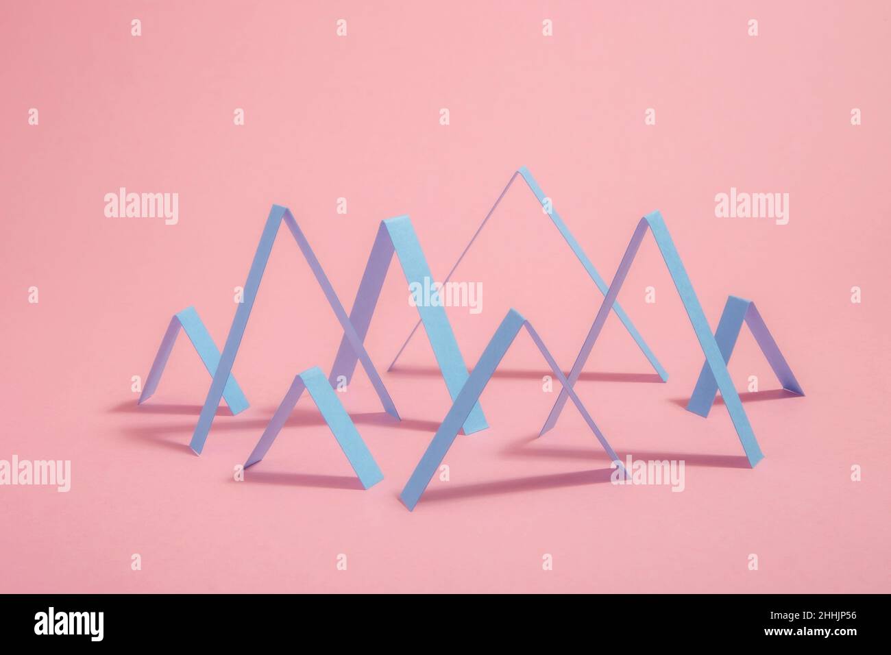 Les lignes géométriques de Zig Zags abstraites créatives sont disposées dans un motif graphique placé sur fond rose avec ombre dans un studio moderne et lumineux Banque D'Images