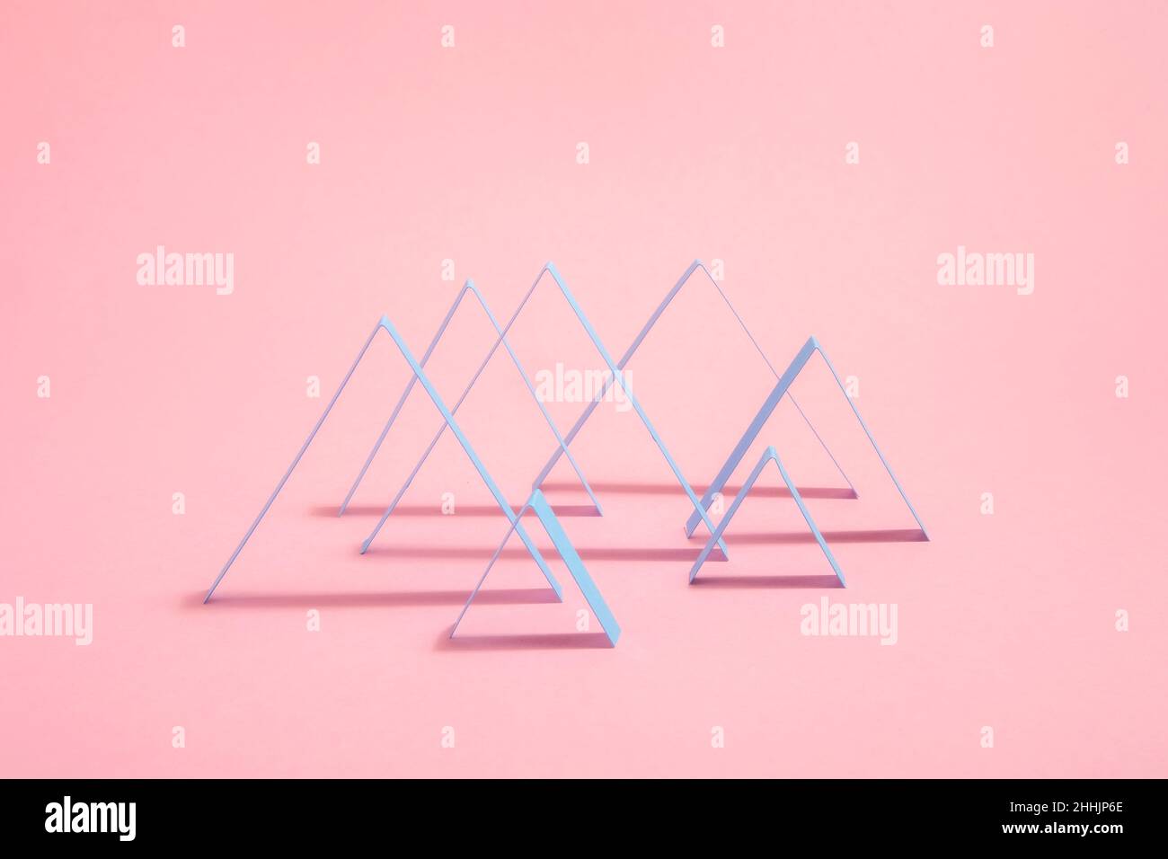 Les lignes géométriques de Zig Zags abstraites créatives sont disposées dans un motif graphique placé sur fond rose avec ombre dans un studio moderne et lumineux Banque D'Images