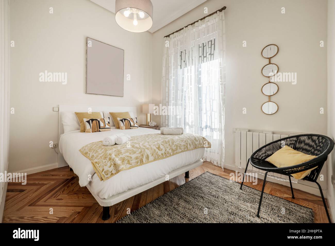 chambre aux tons clairs au décor contemporain avec lit king-size et parquet en pin à chevrons Banque D'Images