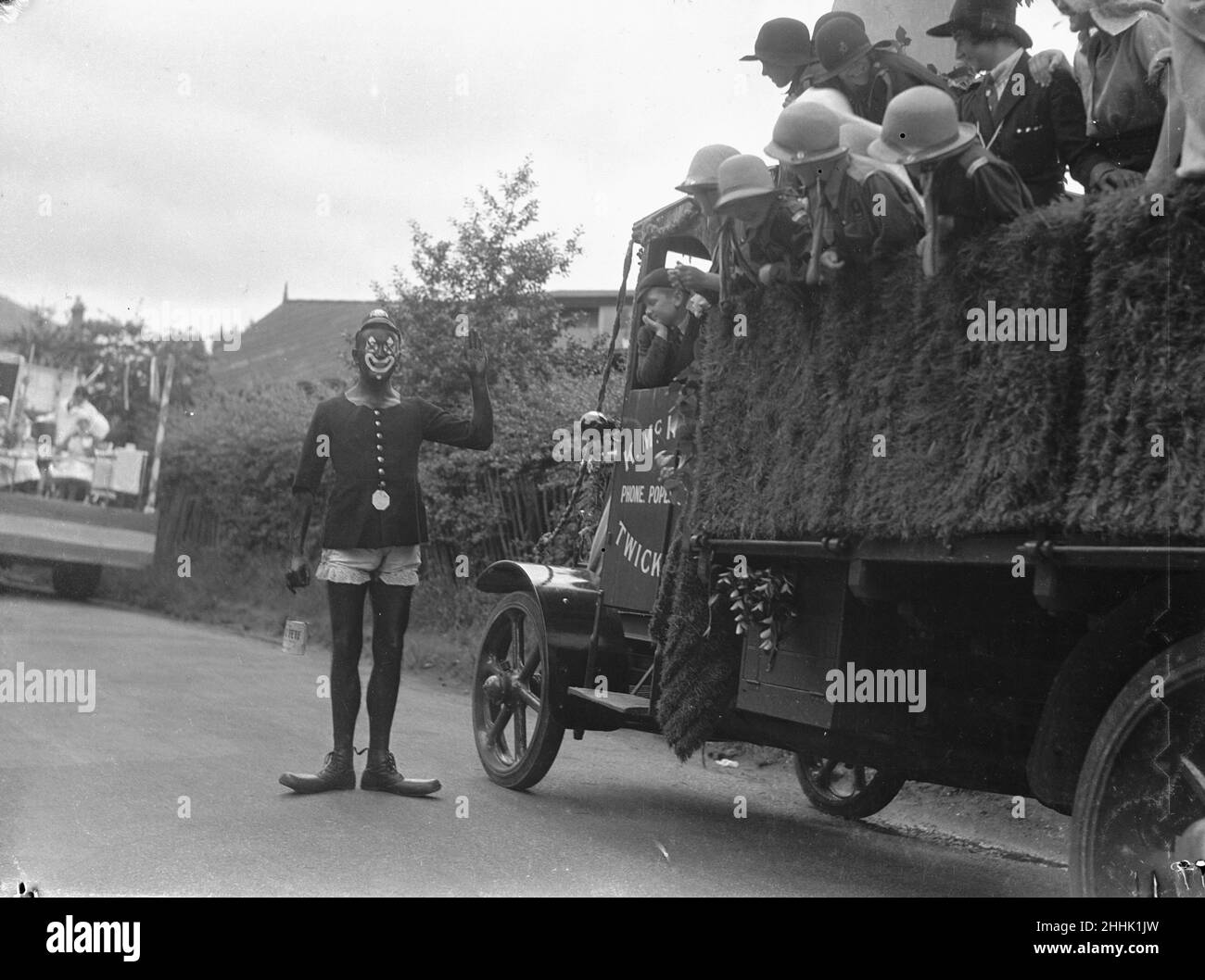 Twickenham Garden Fete et Carnaval.Vers 1930A, un homme a été mis à l'eau dans de la peinture graissée, vêtu d'un policier comique, qui arrête le char du carnaval des Guides et des Brownies Banque D'Images