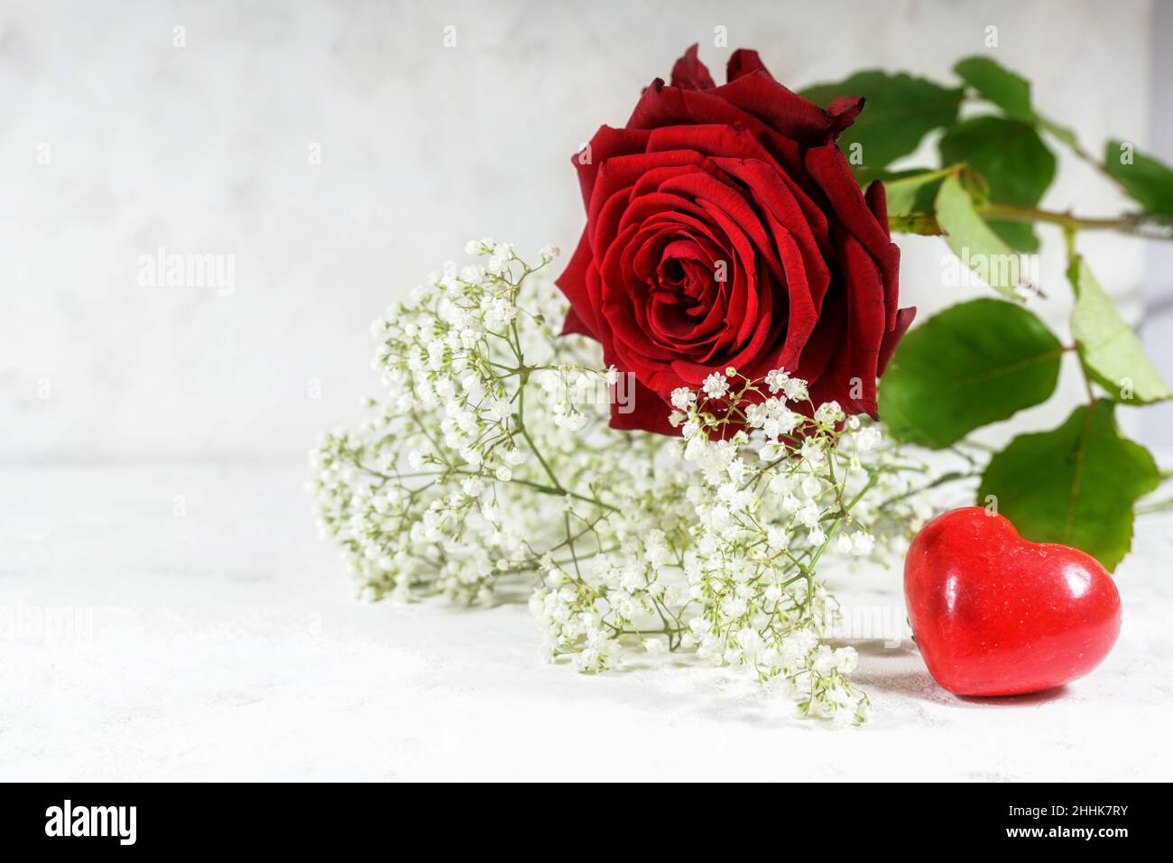 Rose rouge, petite forme de coeur et fleurs blanches sur fond clair, concept d'amour pour la Saint-Valentin, espace de copie choisi foyer, étroit Banque D'Images