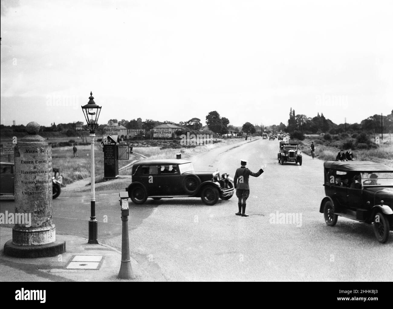 Un patrouilleur AA dirige le trafic des vacances de la banque d'août à l'extérieur des Arms d'Orléans situé à la jonction de Portsmouth Road et Station Road, Esher 1st août 1932 Banque D'Images