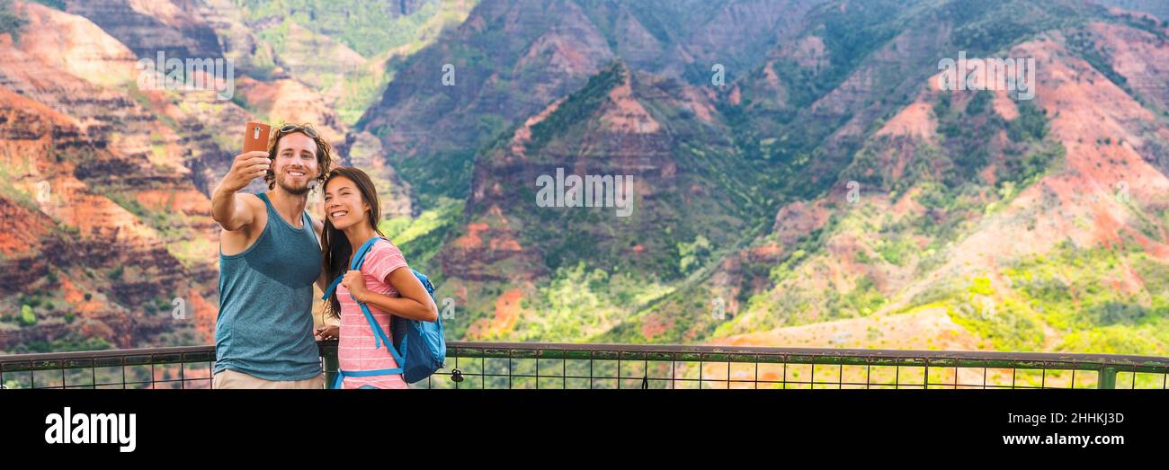 Hawaï nature randonnée voyage couple touristes prenant selfie au point de vue de Waimea Canyon belvédère.Vacances d'été les voyageurs appréciant les activités de plein air à Banque D'Images