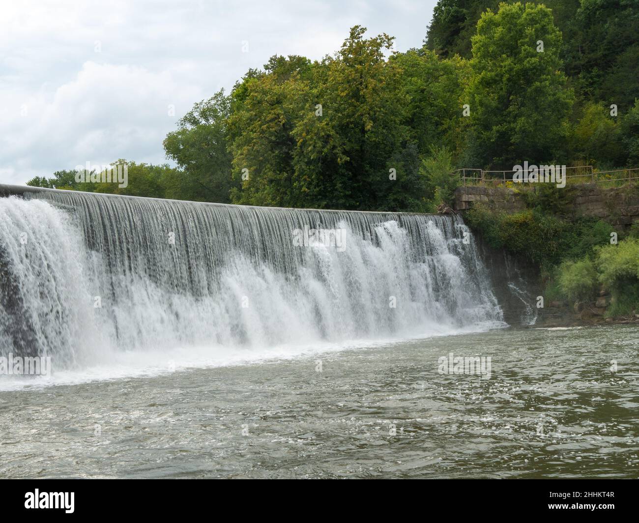 La brume s'élève d'une cascade de Weir sur la rivière Root à Lanesboro, Minnesota, par une journée nuageux. Banque D'Images