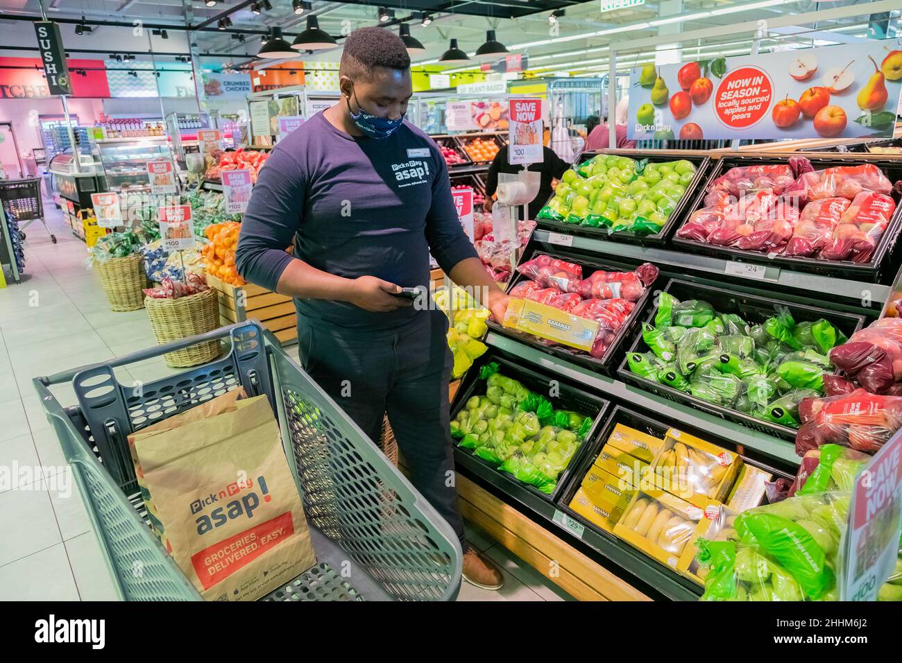 Cape Town, Afrique du Sud - 9 septembre 2021 : un membre du personnel cueille des produits à partir de l'étagère pour un service de livraison express à domicile Banque D'Images